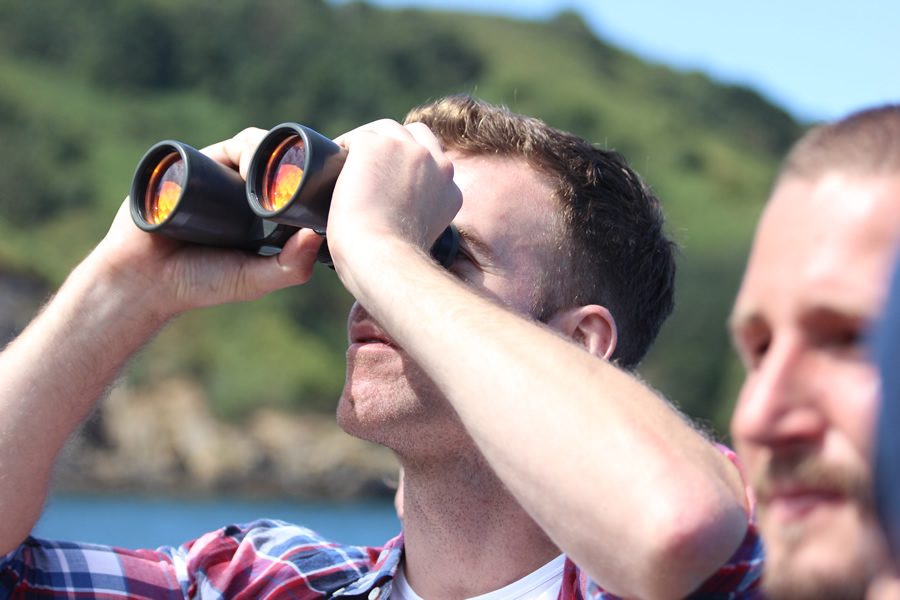 Russell Isabelle looking through binoculars on a Sark boat trip