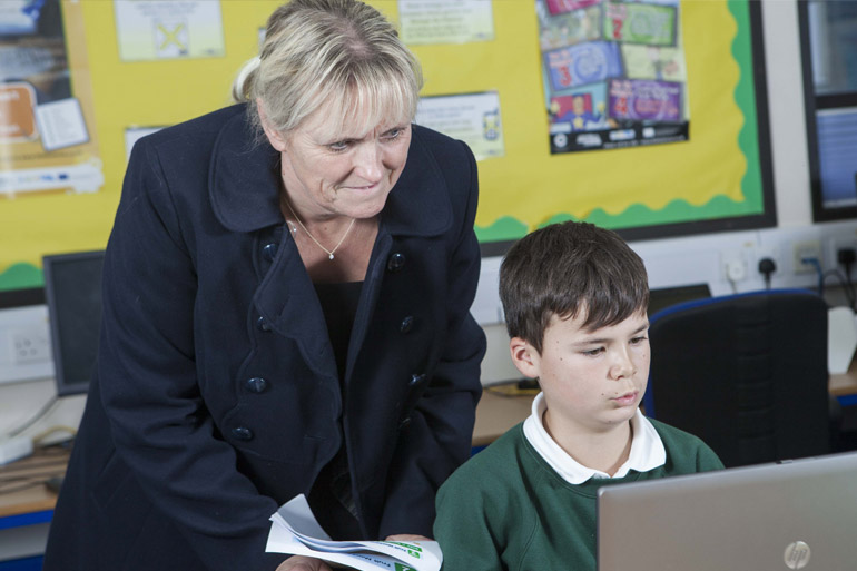 Tracey Moore with a child looking at their computer screen